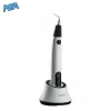 Cordless ultrasonic root canal irrigation activator (iUe1) handpiece docked in its charging stand with power indicator lit